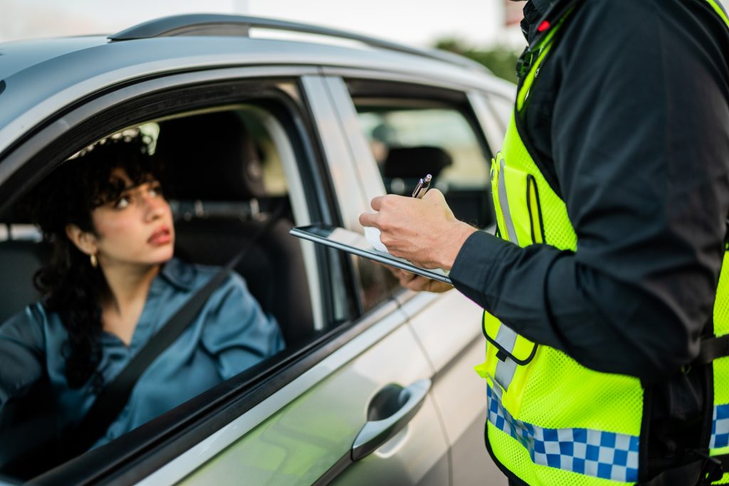 A female driver being stopped by the police and having her details checked.